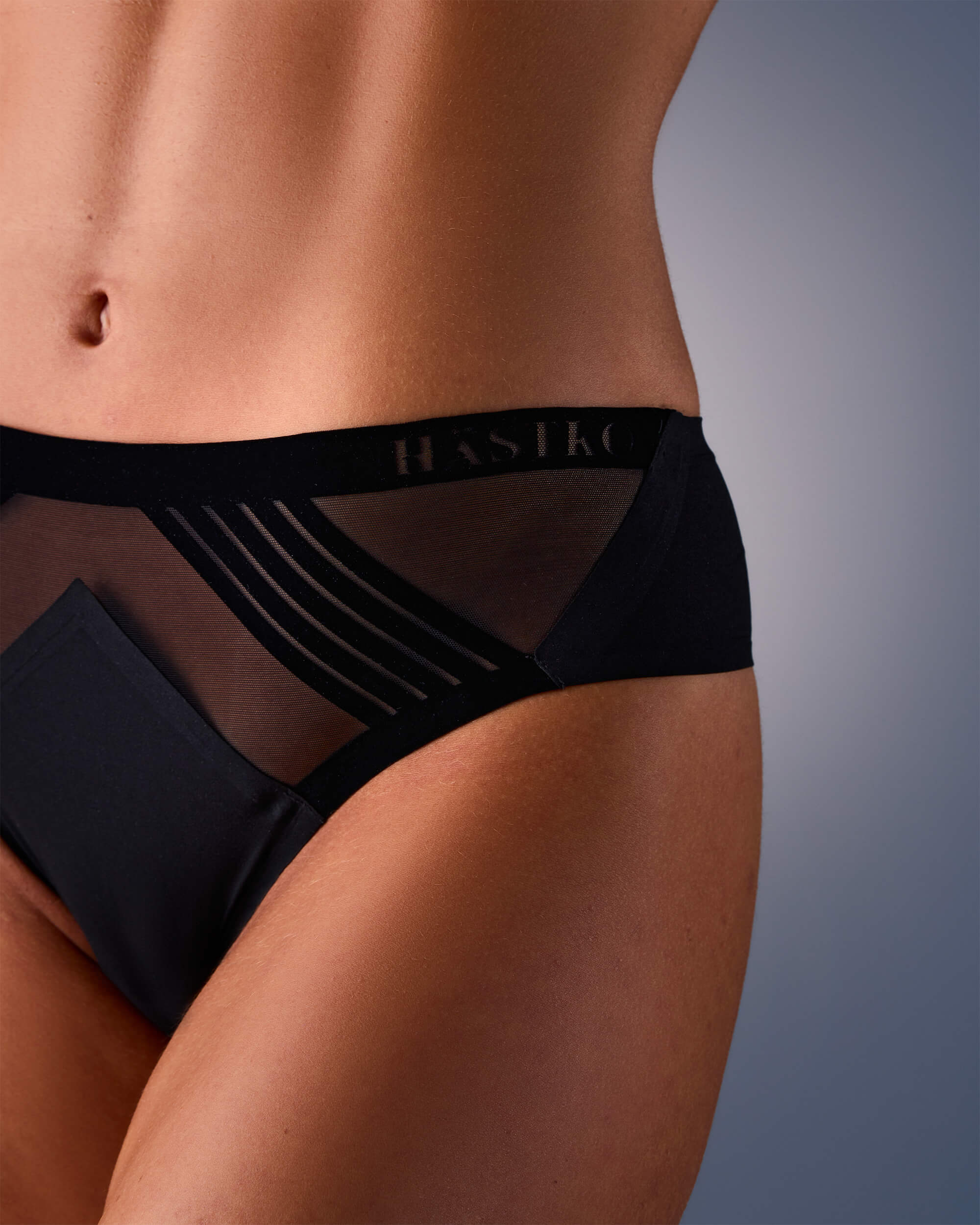 femme portant un tanga de sport sans couture hastko TANGA N°23 #color_true-black